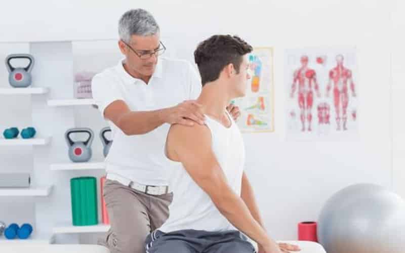 Chiropractor adjusting a young mans back