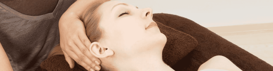 A woman laying down having her neck stretched by a Chiropractor 