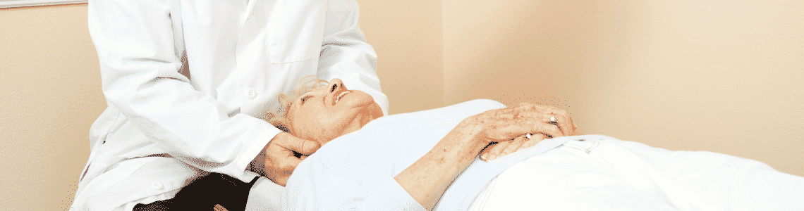 chiropractor adjusting older woman head