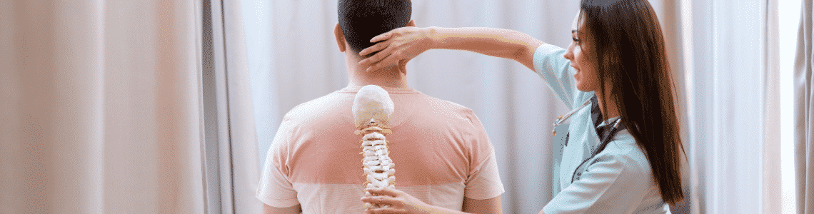 woman holding spine model up to patient 