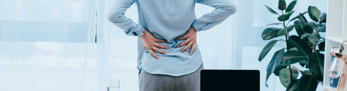a women holding her lower back with two hands