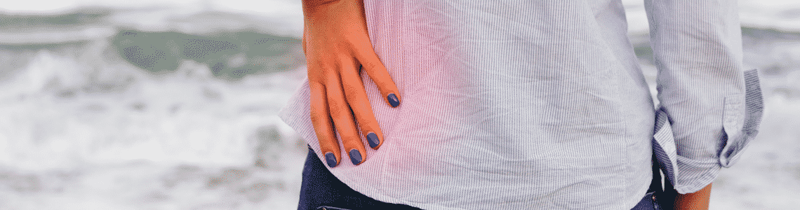 person with blue nails holding hip