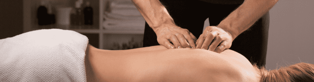 A male massage therapist giving a woman a massage.