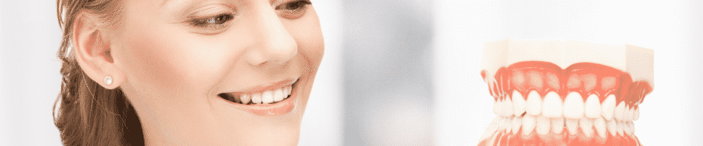 woman smiling looking at teeth model