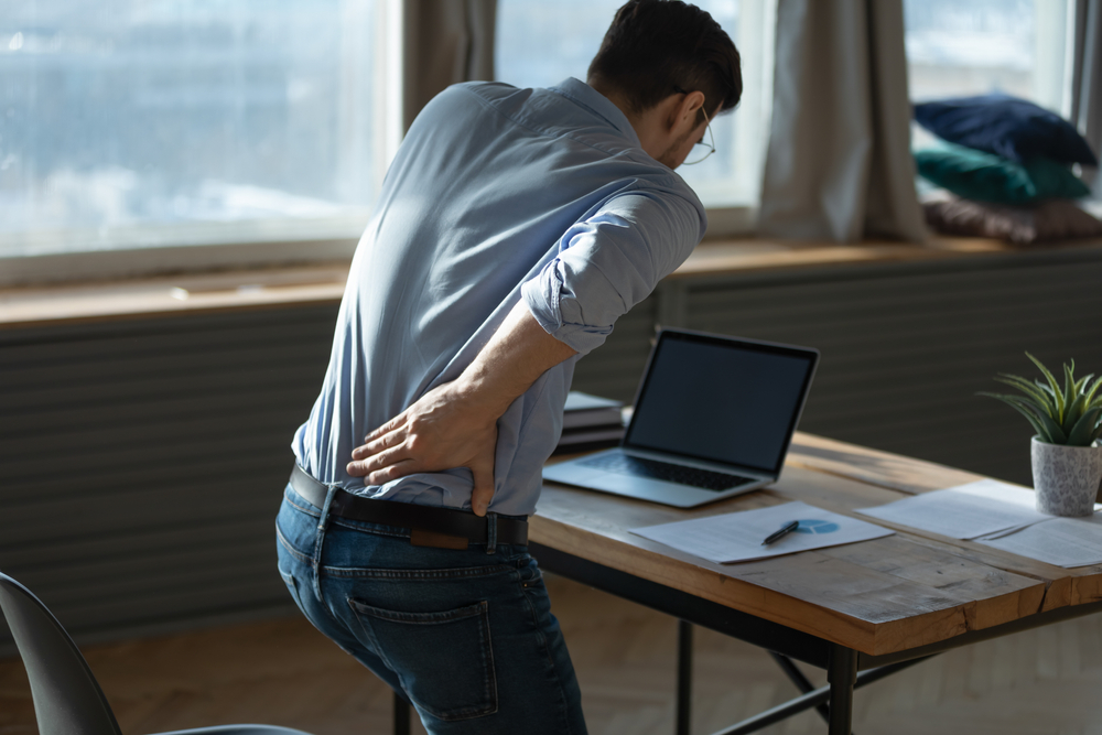 Rear view young man suffering from sudden backache